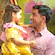 A dad holds his young daughter, who is dressed in a princess costume and a sash that reads Bibbidi Bobbidi